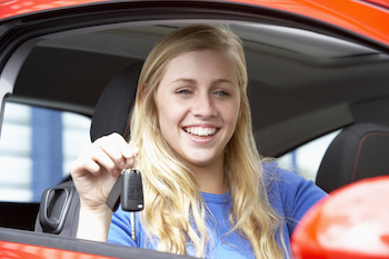 young female driver holding up car key