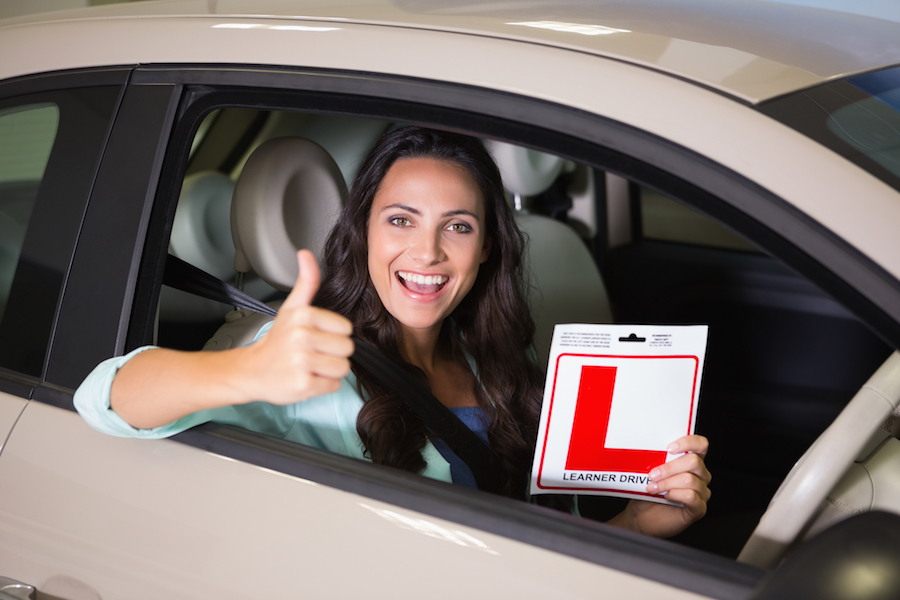 woman holding learner driver sign